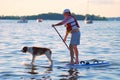 MADISON, WI - JULY 3rd, 2014: Brett Hulsey paddle boarding with his dog Penny