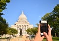 Pov of woman taking photograph with a smartphone of the capital building in Madison, Wisconsin