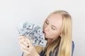 Close-up of a girl sniffing money. Madness and greed from currency. The concept of corruption and getting money at any cost.