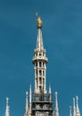 Madonnina atop Milan Cathedral at the height of 108.5 m in Milan, Italy. Golden statue of Madonna on spire on the blue sky Royalty Free Stock Photo