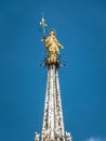 Madonnina atop Milan Cathedral at the height of 108.5 m in Milan, Italy. Golden statue of Madonna close-up on the blue sky Royalty Free Stock Photo