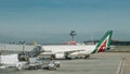 Boarding Alitalia Jet airplane at Madrid`s Bajaras airport, Spain with main terminal in the background