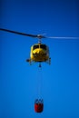 MADRID, SPAIN - AUGUST 3 : Fire rescue heavy helicopter with water bucket, goes to a fire in Madrid on August 3, 2013, Spain. Royalty Free Stock Photo