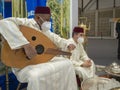 Moroccan musician tuning an Arabian lute (oud) at the Morocco stand in FITUR 2022