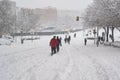 MADRID, SPAIN - JANUARY 9, 2021. Sheltered people walking on the snow-filled road.