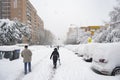 MADRID, SPAIN - JANUARY 9, 2021. Sheltered people walking on the snow-filled road.