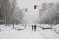 MADRID, SPAIN - JANUARY 9, 2021. Sheltered people walking on the snow-filled road.