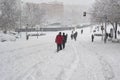 MADRID, SPAIN - JANUARY 9, 2021. Sheltered people walking on the snow-filled road.