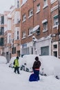 Madrid Spain - January 2021: two people with snowshoes snow goggles a sled in a street covered in snow due to Filomena Storm