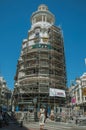 Building being refurbished with scaffolding and woman in Madrid