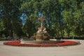 Fountain with statues and bushes in a park of Madrid