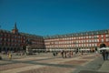 People on the Plaza Mayor with old large building in Madrid