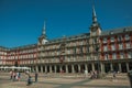 People on the Plaza Mayor with old large building in Madrid