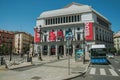 Royal Theatre on busy square with people and bus stop in Madrid