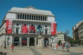 Royal Theatre on busy square with people and statue in Madrid