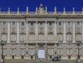 Ornate baroque architecture of the Royal Palace viewed from Plaza de Oriente and police car outside in Madrid, Spain