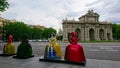 Four colourful women's statues in front of a roundabout with the Puerta de Alcala in the back before the pandemic