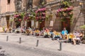 Cozy street in Madrid with small restaurant with outdoor tables in city center near Plaza de San Miguel full of tourists eating