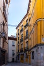 Narrow Spanish medieval cobbled street in Madrid with residential houses, Spain