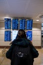 Madrid, Spain: November 15 2022. Young woman standing with her backpack looks at schedule on airport station. Themed public