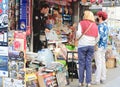 Madrid, Spain - October 12, 2021: elder Spanish women in virus protective masks buying newspapers from local vendor in kiosk on