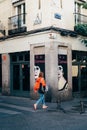 Woman walking by cafe storefront in Lavapies quarter in Madrid