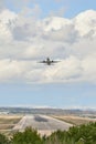 Runway with rubber marks from aircraft landings, while a Boeing 737 aircraft of the Blue bird cargo airline takes off