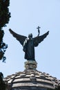 Guardian angel with toga and a cross in his hand guarding from the cupola, the pantheon of Perinat.Cemetery of San Isidro, Madrid