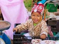 MAE SALONG, THAILAND - DECEMBER 17. 2017: Portrait of a happy toddler baby from Akha hill tribe in a shopping box on market with