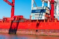 Maersk, CMA CGM, Hamburg Sud shipping containers stacked aboard bright red container ship Royalty Free Stock Photo