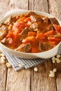 Mafe or Maafe is an authentic African peanut stew made in beef, spicy, creamy peanut butter and tomato sauce closeup in the pan.