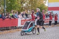 A young man with a baby in a stroller is running a marathon. Active and healthy lifestyle. Leisure sports activities for people