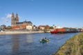 Magdeburg historical downtown, Elbe river, the ancient medieval cathedral with coming by big cargo container ship, barge, in