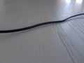 mage of black electronic cable on a white wooden table