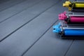 Magenta, cyan and yellow toner cartridges for color laser printers stacked on gray wooden background Royalty Free Stock Photo