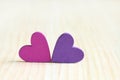 Magenta and lilac wooden hearts on wooden board