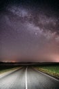 Night Starry Sky Above Country Asphalt Road In Countryside And Green Field. Night View Of Natural Glowing Stars And Royalty Free Stock Photo