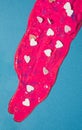 Magenta paint with candy hearts on a pastel blue background. Royalty Free Stock Photo