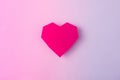Magenta paper heart on a holographic vibrant gradient background. Minimal surrealism flat lay love concept.