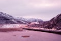 Magenta polar sunset. Highway between the Arctic hills. Northern winter road, turn on the road