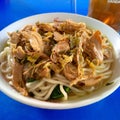 Magetan 20 September 2023 A bowl of chicken noodles on a white bowl with a blue table at Gilis Magetan Safa Es shop