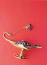 Magic Antique Aladdin Lamp on red background. flat lay. Royalty Free Stock Photo