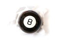 Magic ball of predictions billiard eight. Through a hole in white paper. Isolated on a white background Royalty Free Stock Photo