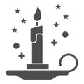 Magic candle solid icon, Halloween concept, burning candle and stars sign on white background, wax candle on candlestick