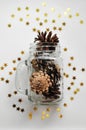 Magic Christmas card with shining stars and cones in a glass jar and caramel. Royalty Free Stock Photo