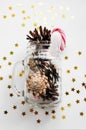 Magic Christmas card with shining stars and cones in a glass jar and caramel. Royalty Free Stock Photo