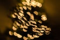 Magic holidays christmas defocused gold bright lights, bubbles and glitters in shape of christmas tree bokeh soft blur background Royalty Free Stock Photo