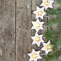 Magic Christmas theme: cozy warm lights garland stars and fir branches on rustic wooden background. top view. over hand Royalty Free Stock Photo