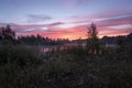 Magic colourful sunrise by the lake with morning fog. Silhouette of trees, meadow and water with colourful reflections. Beautiful