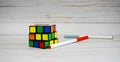 Magic Cube, Rubik`s Cube, and pencils on wooden table background. 3D combination puzzle. Royalty Free Stock Photo